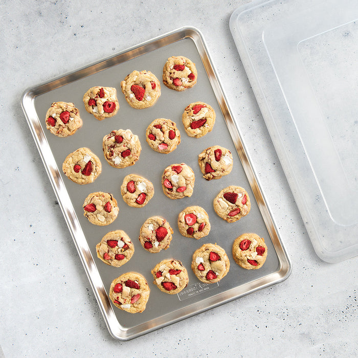 Big sheet pan with clear lid holding baked cookies