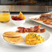 Large slanted bacon tray with cooked bacon in a breakfast spread